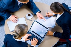 Image of three business people working at meeting